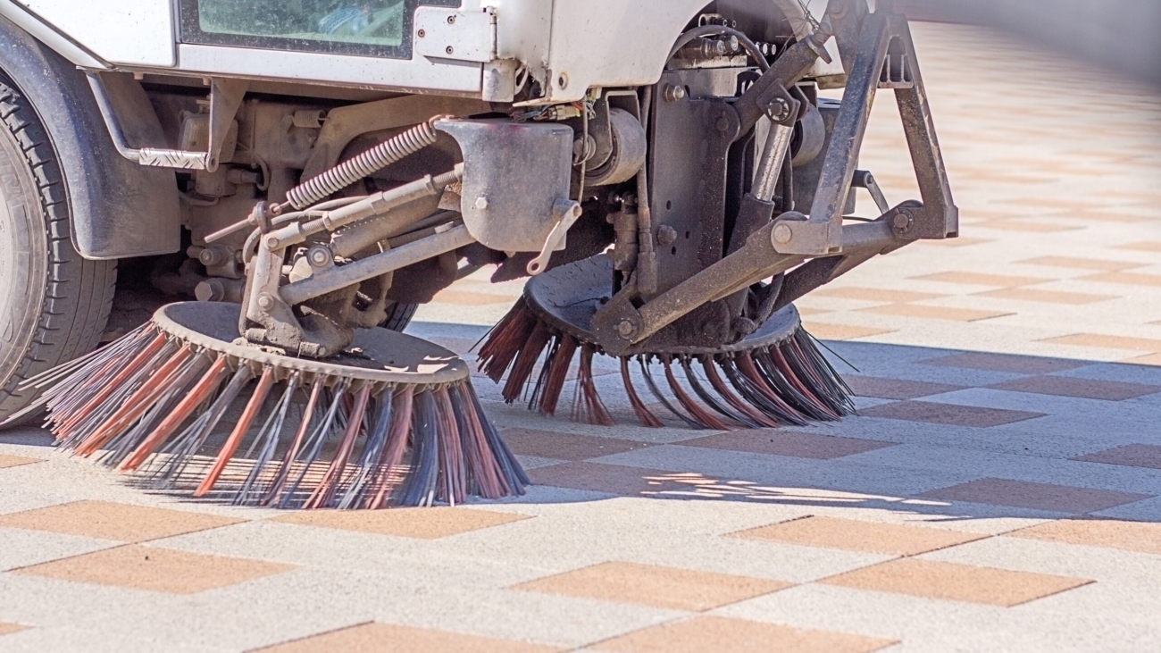 A,Close-up,Of,A,Street,Sweeping,Machine,Cleaning,A,Dusty